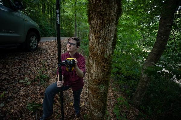 A researcher uses GPS in Alabama forest land.